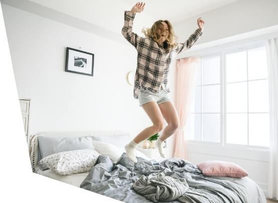 Studentisches Wohnen an der HDBW - Mädchen hüpfend auf dem Bett Studentisches Wohnen an der HDBW - Mädchen hüpfend auf dem Bett